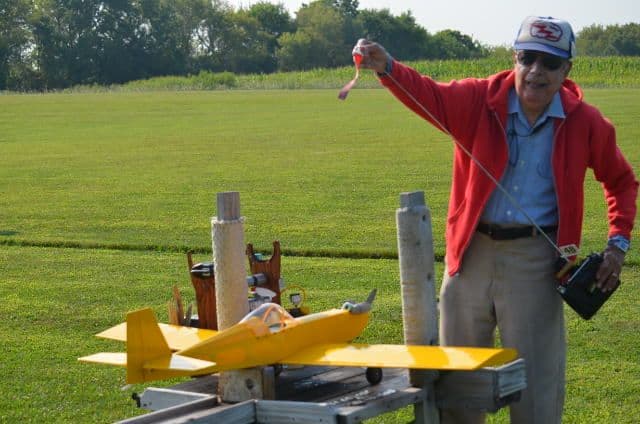 A club member with a yellow model airplane